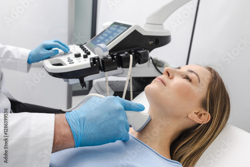 Woman patient receives thyroid diagnostics. Treatment of thyrotoxicosis, and hypothyroidism. Ultrasound diagnostics of endocrine system and thyroid