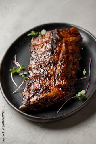 Grilled ribs with radish and microgreen on a plate