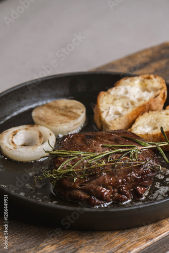Grilled beef steak with rosemary and toasted baguette