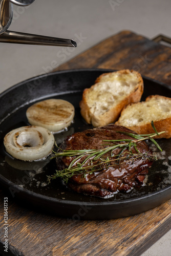 Pan-fried steak with toast and rosemary, drizzled with olive oil