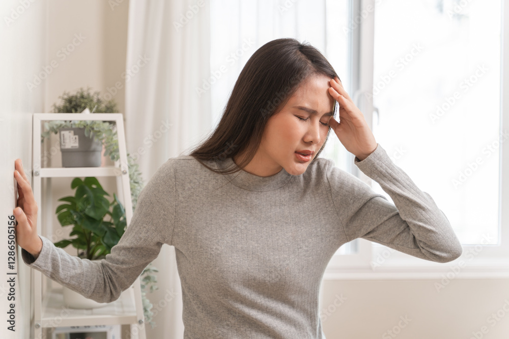 Young Asian females feeling dizzy after standing too fast, have symptoms of low blood pressure Young Asian females feeling dizzy after standing too fast, have symptoms of low blood pressure