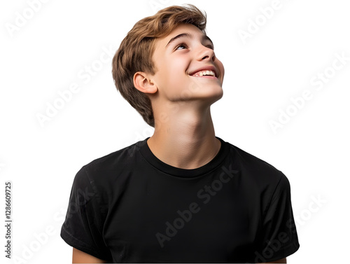 Young boy with joyful expression looking upwards, isolated on black background, smiling with hope and curiosity