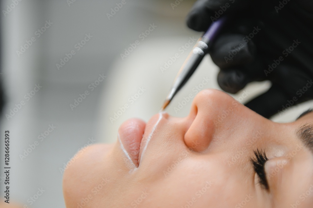 Woman With Permanent Lips Makeup at Beauty Salon During Permanent Makeup Tattoo While Drawing Contour with White Lip Pencil Woman With Permanent Lips Makeup at Beauty Salon During Permanent Makeup Tattoo While Drawing Contour with White Lip Pencil