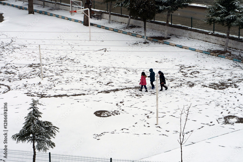 It snowed and the little friend kids are walking on the snow,