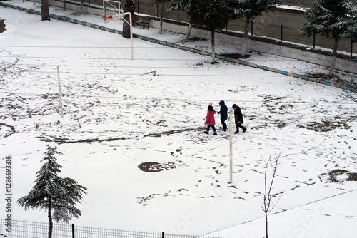 Obraz na płótnie It snowed and the little friend kids are walking on the snow, w salonie