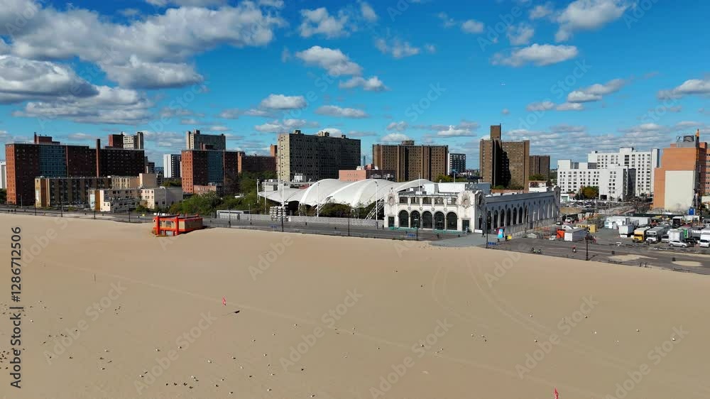 Expansive sandy beach in Brooklyn, United States, with a backdrop of residential buildings and an iconic white structure. Expansive sandy beach in Brooklyn, United States, with a backdrop of residential buildings and an iconic white structure.