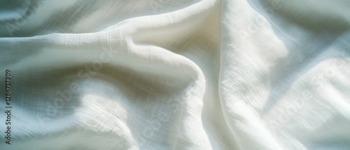 Soft white fabric gently cascades with graceful folds, creating a serene and tranquil visual of cozy elegance and delicate textures.