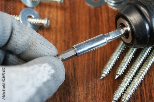 Assembler's work process. Removing the Torx bit from the bit adapter. 