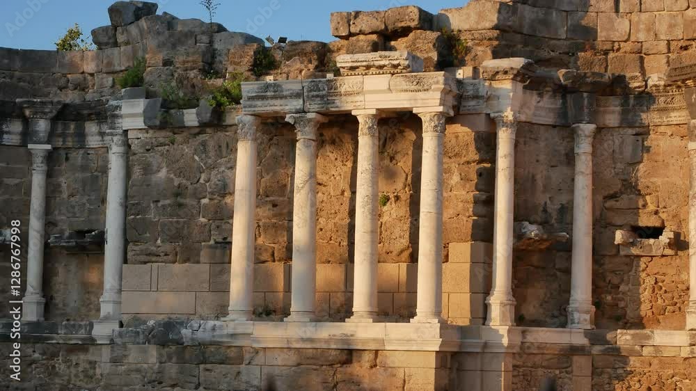 Ancient high stone columns and remains of stone walls of the ancient theater. Ancient architecture. Ancient high stone columns and remains of stone walls of the ancient theater. Ancient architecture.