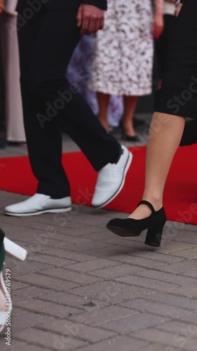 Red carpet with ropes and golden barriers on a luxury party entrance, cinema premiere film festival event award gala ceremony, wealthy rich guests arriving, outdoor decoration elements, summer day