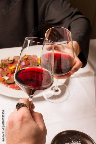 couple toasts with red wine at restaurant