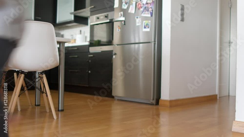 Children are playfully running and enjoying themselves indoors. The space features a modern kitchen and a bright, inviting atmosphere, perfect for their energetic activities.
