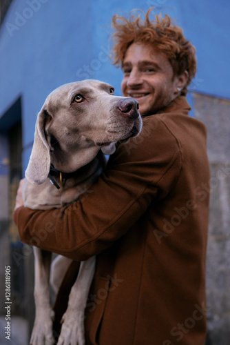 nice grey dog ​​with his owner in his arms on the street happy