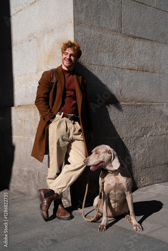 Young ginger hair boy with his dog posing on the street in the city with sunlight lifestyle