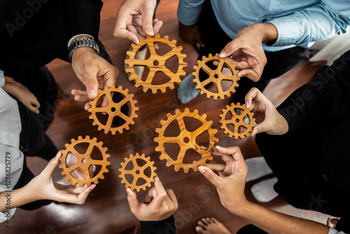 Group of multiracial business people joining gear wheels together as effective unity and productive teamwork concept. Efficient system business team process for solution solving. Meticulous