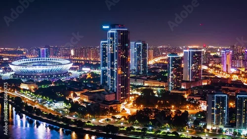 Wallpaper Mural Stunning aerial night view of a modern city skyline illuminated by bright lights, featuring skyscrapers and a stadium. Torontodigital.ca