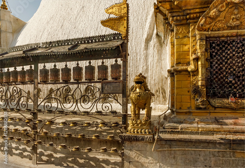 Swayambhunath Stupa  featuring Prayer wheels, butter lamps and a guardian lion statue photo