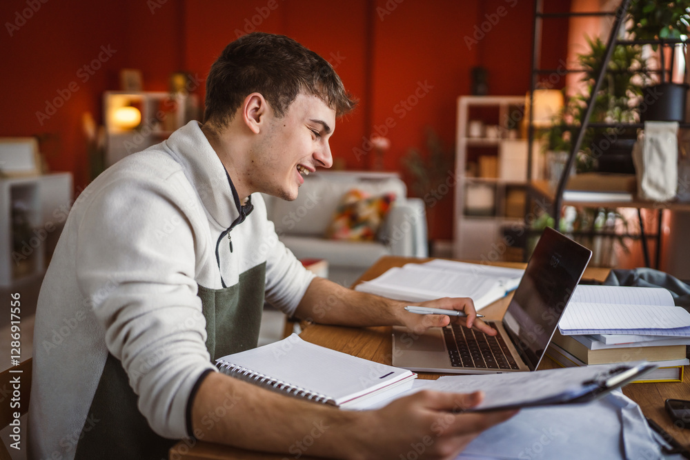 young man student study for exam notebook, laptop and clipboard at home young man student study for exam notebook, laptop and clipboard at home