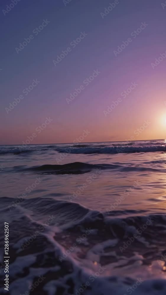 Low-angle video capturing gentle waves lapping the shore at sunset, with golden reflections on the water creating a serene, tranquil scene. Mobile wallpaper ratio. Low-angle video capturing gentle waves lapping the shore at sunset, with golden reflections on the water creating a serene, tranquil scene. Mobile wallpaper ratio.