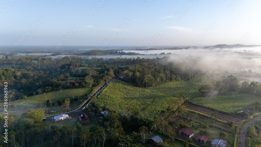 Aerial view of foggy fields and country roads at sunrise in La Fortuna, Costa Rica. Aerial view of foggy fields and country roads at sunrise in La Fortuna, Costa Rica.