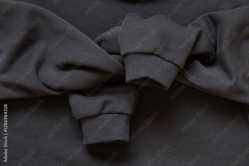 Fototapeta premium Sleeves tied in a knot on a black cotton sports sweater