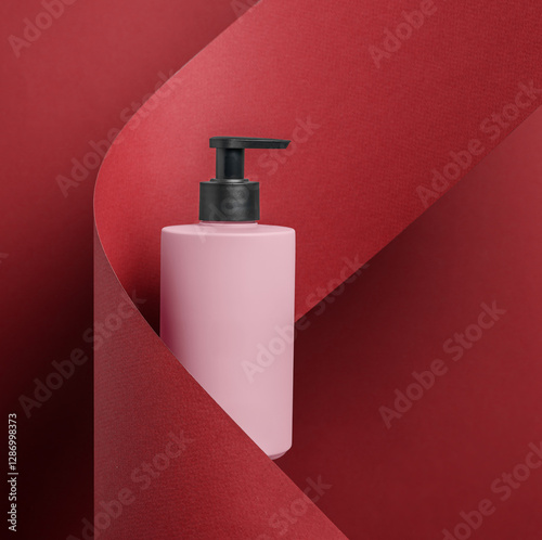 A stylish pink pump bottle displayed against a bold red background, creating eyecatching appeal