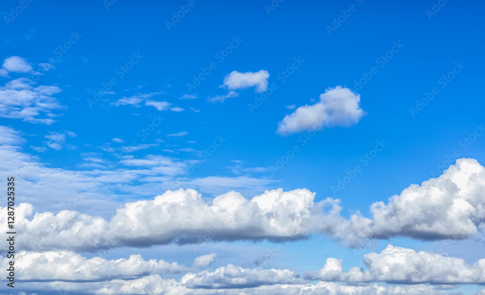 A vast blue sky with scattered clouds forms a dreamy, calm scene. The clouds vary in size and shape, adding depth and texture to the beautiful landscape. A vast blue sky with scattered clouds forms a dreamy, calm scene. The clouds vary in size and shape, adding depth and texture to the beautiful landscape.