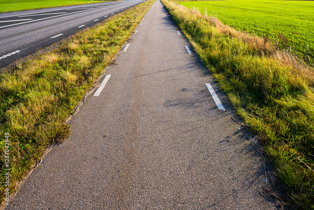 paved bicycle lane through open countryside. paved bicycle lane through open countryside.