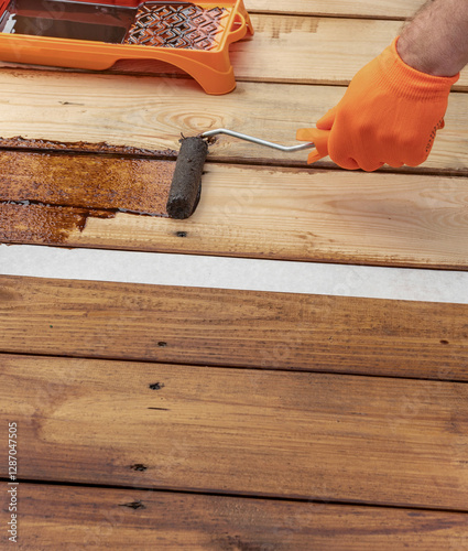 Wallpaper Mural Man is painting a wooden floor with a roller Torontodigital.ca