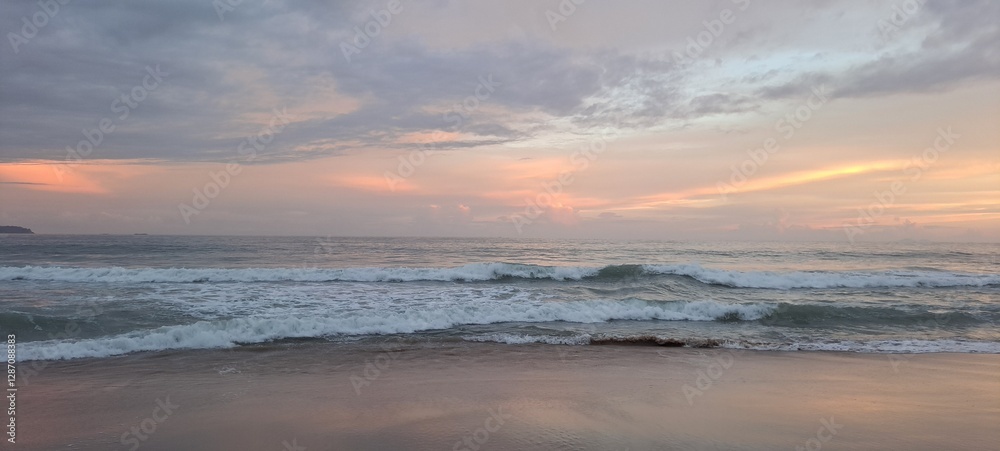 Fototapeta premium O anoitecer em um dia parcialmente nublado na praia do Félix, em Ubatuba, litoral norte paulista, Brasil.