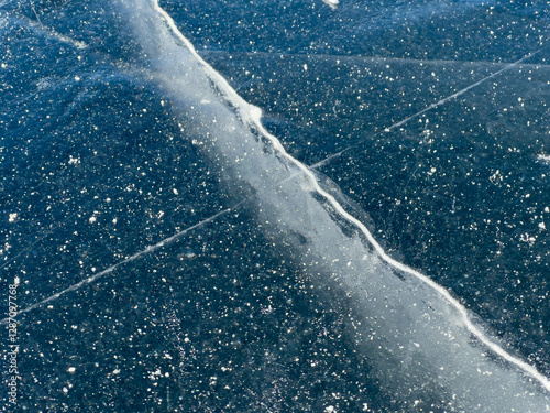 Obraz na płótnie A close-up view of a frozen surface with visible cracks and air bubbles, capturing the intricate details and natural patterns of the ice. w salonie