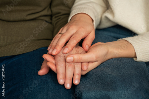 Canvas Print A daughter and mother reunite after a long separation, sitting side by side, holding hands and gently stroking them, sharing a deeply emotional and loving moment, captured in a close-up