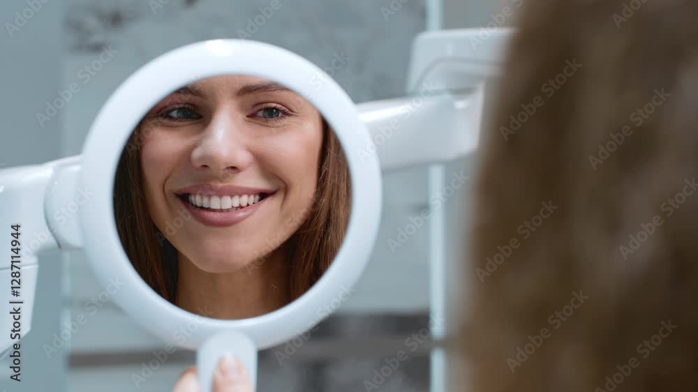 Woman patient smiles at her reflection, highlighting a positive dental experience during a routine check-up.