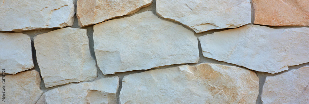 Beige stone wall texture with faded paint for background or design Beige stone wall texture with faded paint for background or design