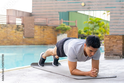 Healthy wellness Asian man sport training fitness plank workout exercise at stadium gym. Young male in sportswear do push-up plank exercise abdominal muscles improve core strength and stability.