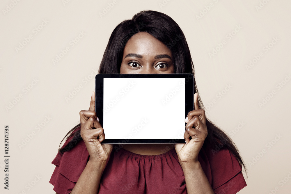 Long-haired black woman hiding her face behind digital tablet with empty screen, african american lady showing nice dating mobile application on pad, mockup, beige studio background Long-haired black woman hiding her face behind digital tablet with empty screen, african american lady showing nice dating mobile application on pad, mockup, beige studio background