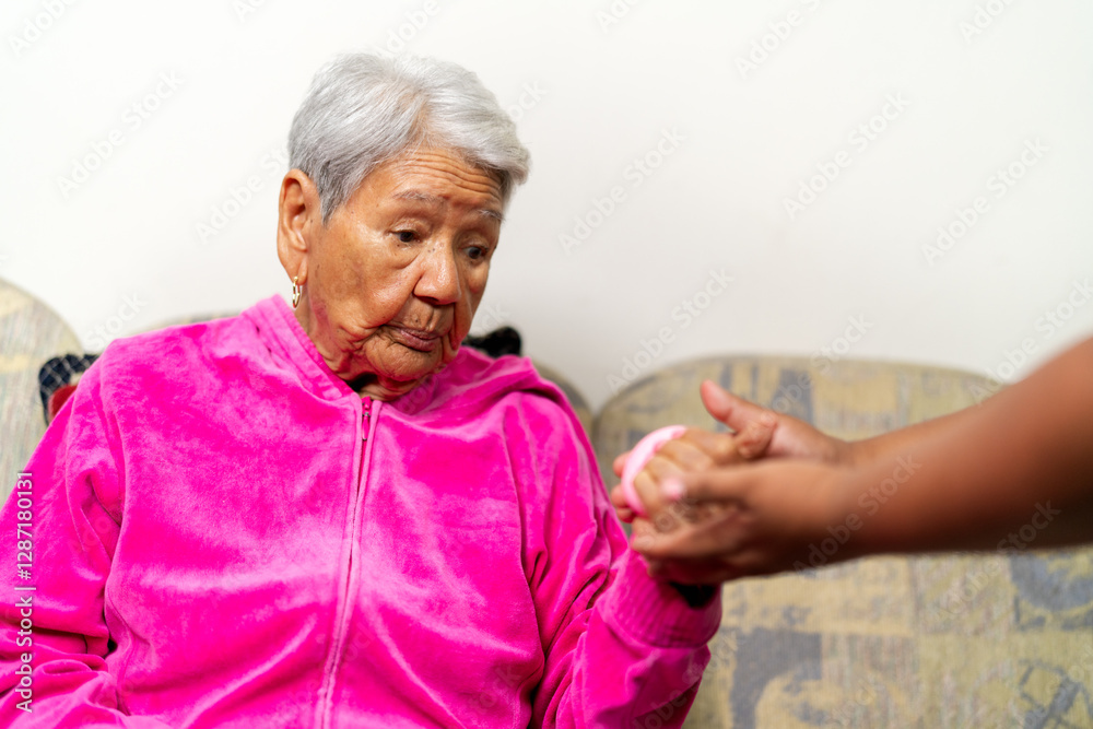 Nurse giving stress ball to senior woman for hand physical therapy Nurse giving stress ball to senior woman for hand physical therapy