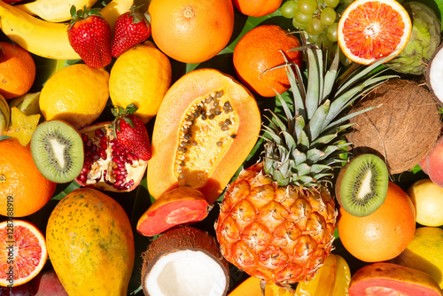 Summer mix of tropical fruits over green leaf