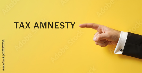 hand point at tax amnesty text on yellow background, tax and payment accounting concept