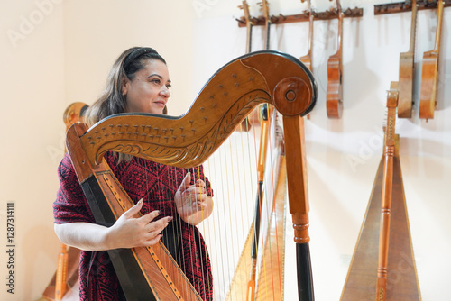 Woman musician playing Paraguayan harp in workshop