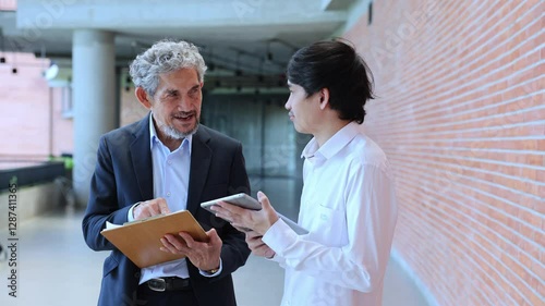 Asian senior professor is giving advice to the college student on the research thesis while sitting in the university faculty for education, academic and business	