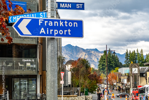 Bilde på lerret A signpost in Queenstown directs travelers and motorists to Frankton Airport on an urban street in town center