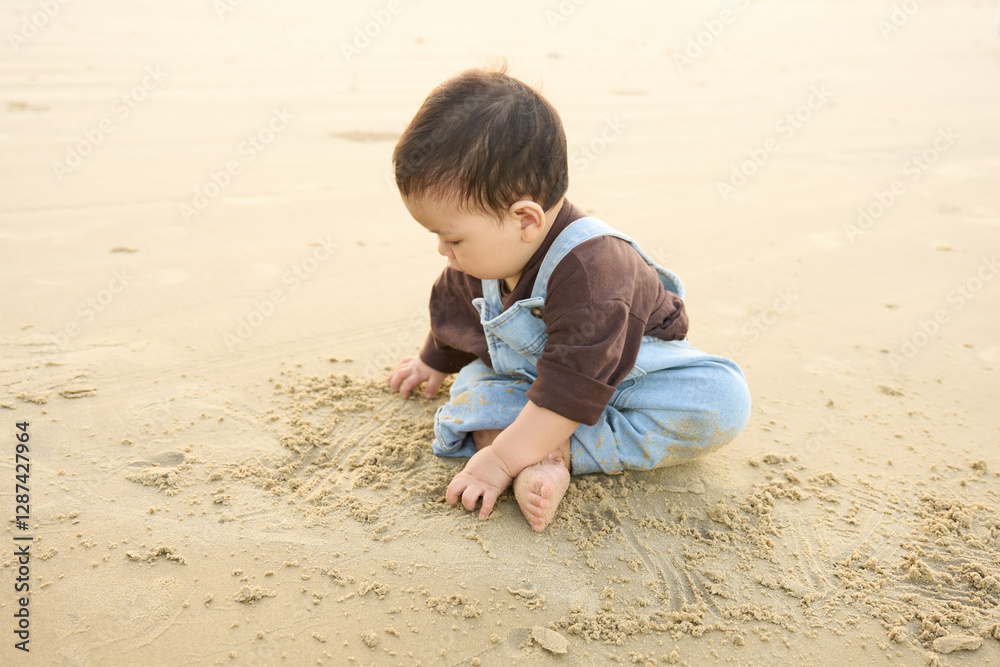 arafed baby boy sitting on the sand playing with sand arafed baby boy sitting on the sand playing with sand