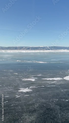Wallpaper Mural Traveling on ice of frozen Baikal Lake. Vertical video of ice cover of  Small Sea with blue ice with cracks and snow crusts. In distance, a mountain range. Winter landscape. Natural background Torontodigital.ca