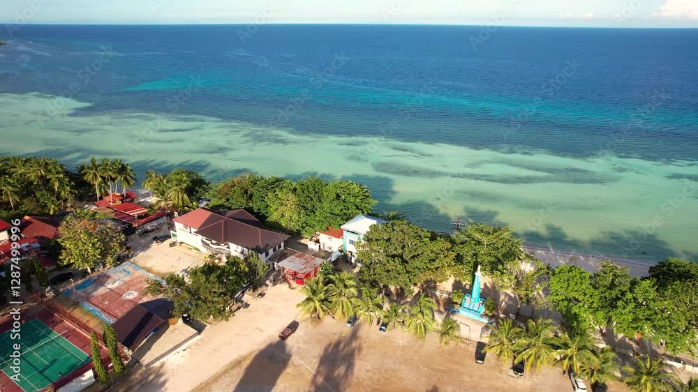 Aerial shot of the town and shoreline of Anda, Bohol, Philippines during the afternoon.