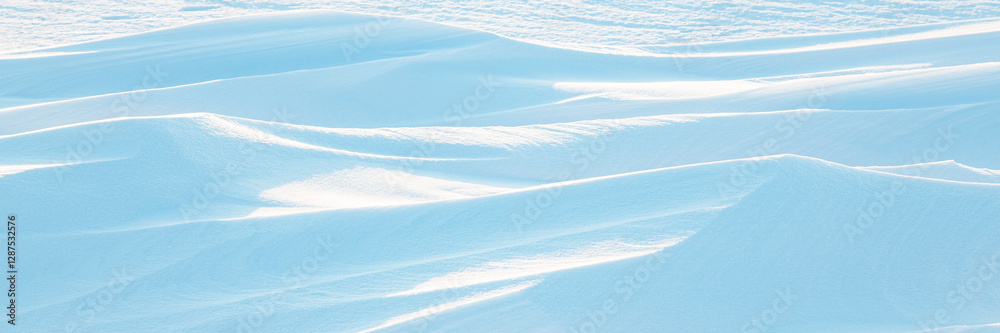 Snow texture. Wind sculpted patterns on snow surface. Wind in the tundra and in the mountains on the surface of the snow sculpts patterns and ridges (sastrugi). Arctic, Polar region. Winter background