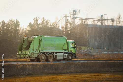 Obraz na plátně Green trash truck during sunrise commute