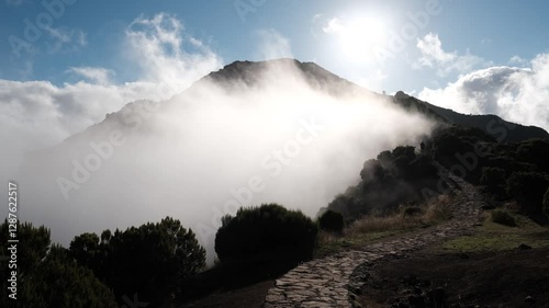 Hikers walking along path into mist towards Pico Ruivo, Madeira Island, Portugal
