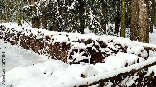 Stacked logs outdoor storage in winter in the forest rural life snowy weather 