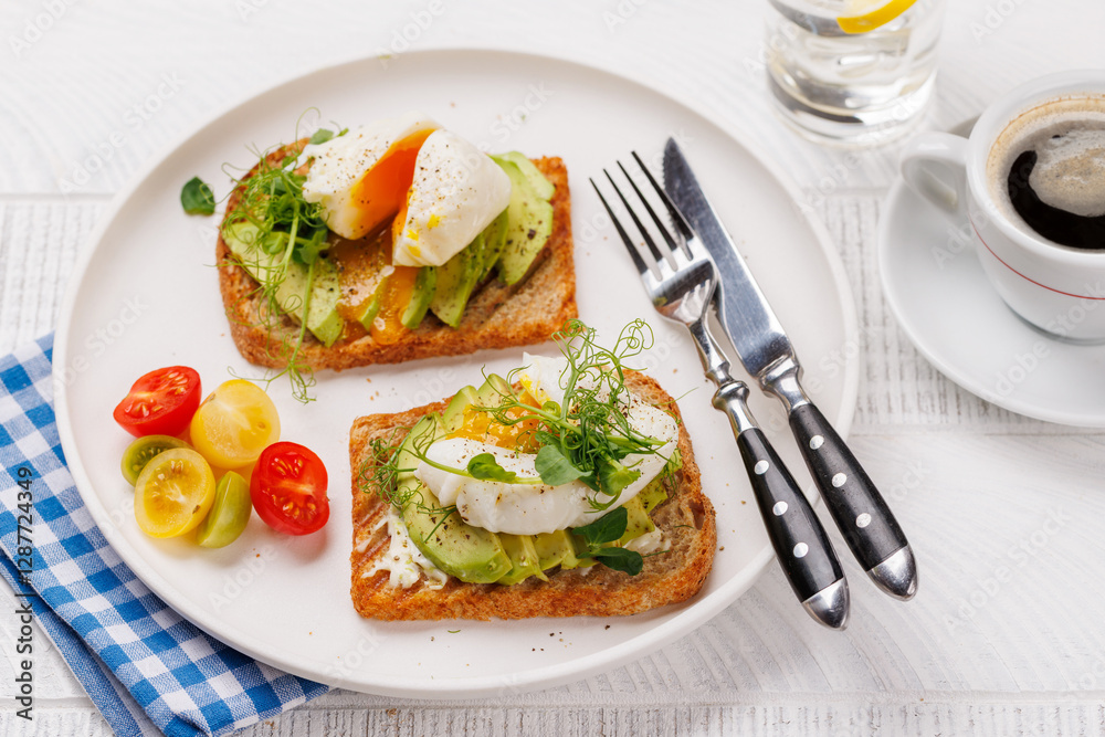 Delicious avocado toasts topped with perfectly cooked poached eggs Delicious avocado toasts topped with perfectly cooked poached eggs